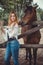 Nice young woman with a horse on rancho, outdoor portrait