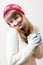 Nice young woman in knitted gloves and cap with a pattern snowflakes, white sweater drink beverage happy smiling