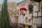 Nice young woman in white coat and red beret joy and happy. Walking near city cafe with baguettes