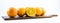 Nicely colored oranges on a white background - front and back lined next to each other on a wooden board