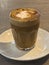 Nicely decorated cup of coffee latte on a nice place creamy froth with caramel topping