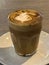 Nicely decorated cup of coffee latte on a nice place creamy froth with caramel topping