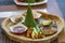 Nicely decorated platter lunch with sauce, rice and vegetable slices served in a white plate on a wooden table in touristic visit