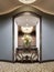 A niche in the wall of the hotel corridor with a mirror and a classic console with flowers and lighting