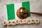 Nigerian flag, judge gavel and wooden cubes with text, concept on the theme of sanctions in Nigeria