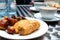 Nigerian meat pie, puff-puff, fish roll and stick meat gizzard pastries or Nigerian small chops in white saucer for Nigerian break