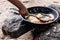 Nigerian Woman stirring Akara Fried Bean Cake on fire in hot oil