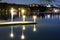 Nigh landscape of light at the pier or dock with very smooth water and building reflection.