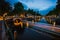 Night in Amsterdam. Lights trails and illuminated bridges on city canal at twilight. Holland, Netherlands. Long exposure