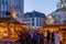 Night atmosphere with crowd of people and illuminated decorated stalls at Christmas Market.