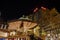 Night atmosphere with crowd of people and illuminated decorated stalls at Christmas Market.