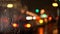 Night blurred city lights background. Abstract urban street cityscape with rain in bokeh effect. Moving cars in the