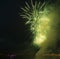 Night city green fireworks above river new year