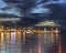 Night city light reflection on sea water ,cloudy sky ,on horizon town pier  on harbor urban  nature landscape