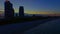 Night city ocean beach front at sunset illuminated by city lights