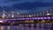 Night cityscape with illuminated bridge at modern embankment