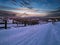 Night countryside road, hoases, hills, groves and farmlands in winter remote alpine mountain village. Ukraine, Voronenko, Moon