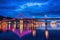 Night european city in colorful lights and reflection in water, Kiev, Ukraine. Pedestrian bridge across the Dnieper river