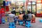 At night, farmers construction workers watch TV in front of a small shop.