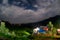 Night fisheye shot of a hill station lit by the light from buildings, a cloudy star studded sky and trees in McLeodganj