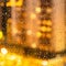 Night illuminated urban house through raindrops