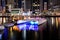 The night illumination of Dubai Marina and catamaran and traditional Dhow boat