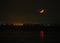 Night image of a half moon setting over Pegwell Bay, Kent, UK, with a reflection of the the moon in the sea