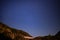 Night landscape with an alpine refuge and starry sky seen from rocky mountains