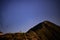 Night landscape with an alpine refuge and starry sky seen from rocky mountains