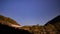 Night landscape with an alpine refuge and starry sky seen from rocky mountains