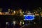 Night landscape with a blue light bridge. Round bench in Bastejkalns, Riga, Latvia