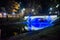Night landscape with a blue light bridge. Round bench in Bastejkalns, Riga, Latvia