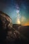 Night landscape of a cliff with a gorge in the background and a vertical Milky Way. Dreamy image in a fabulous way