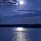 Night landscape of lake, sky with cloud and full moon. Moonlight path reflection