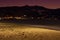 Night landscape with lights mountain village and deserted beach