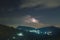 Night lightning strike over mountains resort with star on Mon Jam