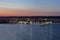 Night lights from the city and the sea port in Varna, Bulgaria at twilight with beautiful striped sky and water