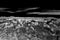 Night Mojave desert landscape with rocks, mountains and black. sky with white clouds