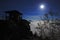 Night with Moon on the lookout. White fog in the valley. Watchtower on the stone hill during night. Night landscape. Hills and