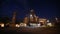 Night panorama of loading grain crops on bulk freighter ship via trunk to open cargo holds at silo terminal in seaport