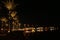 Night panorama with view of illuminated palm trees on seacoast of Hurghada. Tropical resort