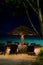 Night paradise beach with deck chair and umbrella