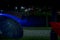 Night park after the rain with illuminated bridge and lighted black and red umbrellas. Underexposed photo.