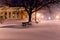 Night photo of city streets during a snowfall. historical center, alley with benches.