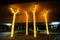 Night photography of artwork `Aspire` trees sculpture gleams bright and gold under the concrete of freeway at Ultimo NSW.