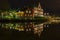 Night picture of a house that is reflected in a river.