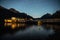 Night pier at mountain lake with tourist boat at night with stars in the sky