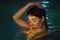 Night portrait of brunette woman swimming in pool with hot mineral water in balneotherapy spa