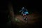 Night riding on a mountain bike in forest. Rider in action at mountain bike sport. Biker riding