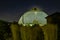 Night scene of the Desert Dome, with the moon barely visible through the top, at Henry Doorly Zoo Omaha Nebraska.